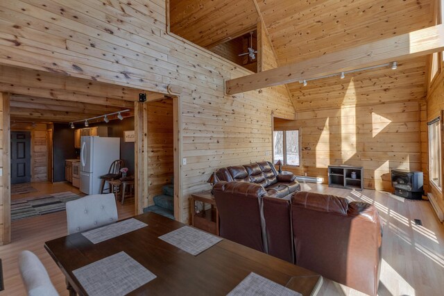 11375 Grouse Loop NW, Walker, MN 56484 - dining room with track lighting, wood walls, light wood-style flooring, wooden ceiling, and high vaulted ceiling