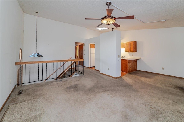 carpeted spare room with lofted ceiling, a textured ceiling, and ceiling fan