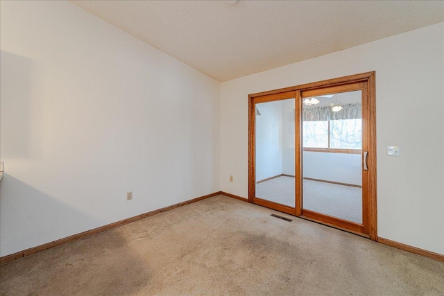 spare room featuring vaulted ceiling and light carpet