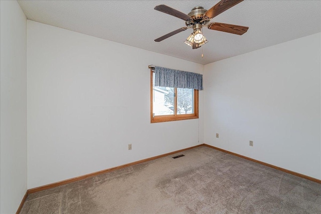 empty room with ceiling fan, carpet floors, and a textured ceiling