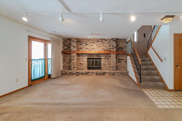 unfurnished living room with brick wall, light colored carpet, a fireplace, and a textured ceiling