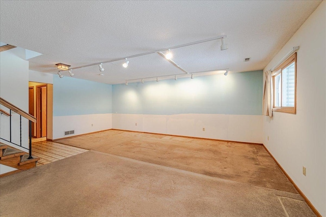 unfurnished room with light carpet and a textured ceiling