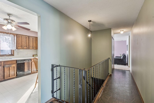 corridor with sink and a textured ceiling