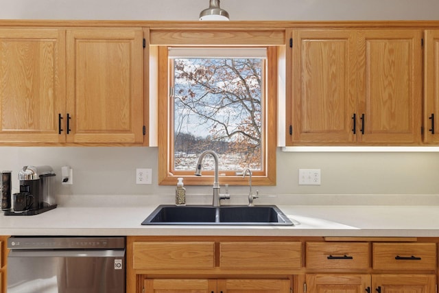 kitchen featuring dishwasher, light countertops, and a sink