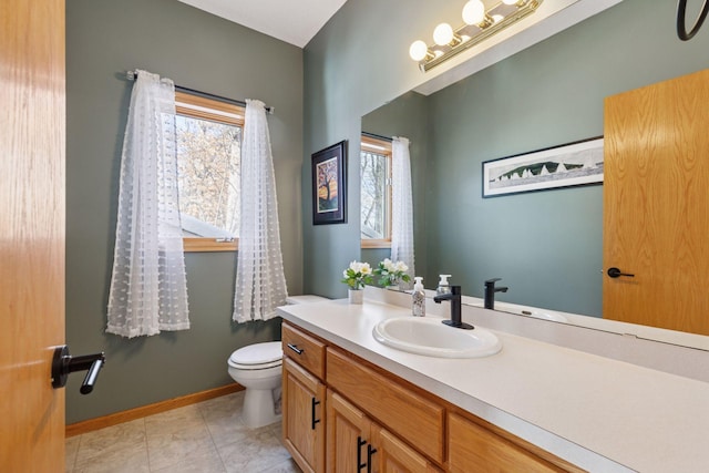 bathroom with vanity, tile patterned floors, toilet, and baseboards