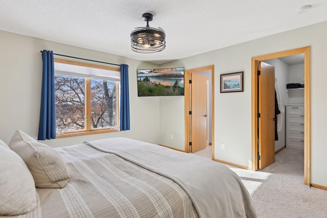 carpeted bedroom with a textured ceiling and baseboards