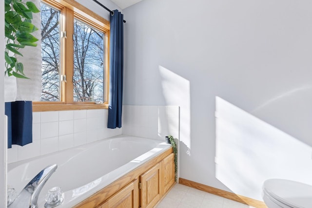 bathroom featuring a bath, tile patterned flooring, toilet, and baseboards