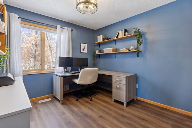 office featuring dark wood finished floors, visible vents, a textured ceiling, and baseboards