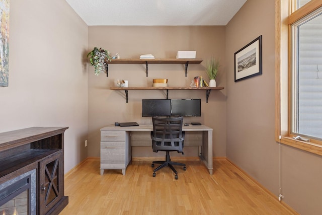 office space with light wood-type flooring and baseboards