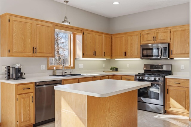 kitchen with a sink, stainless steel appliances, a kitchen island, and light countertops