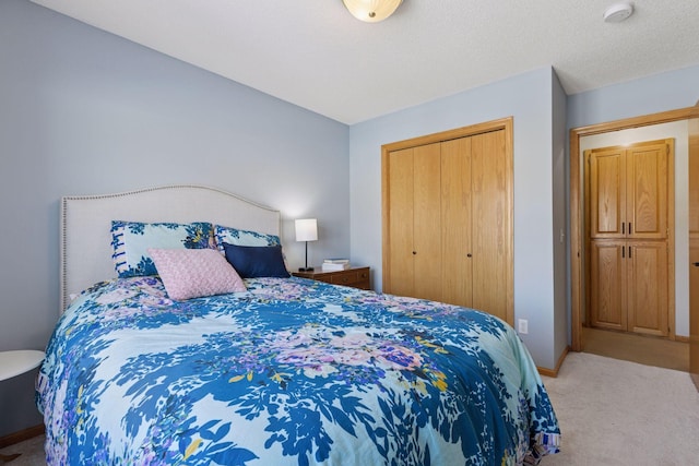 carpeted bedroom featuring a closet, baseboards, and a textured ceiling