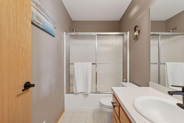 full bath with toilet, vanity, tile patterned floors, combined bath / shower with glass door, and a textured ceiling