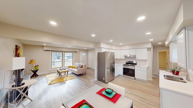 kitchen featuring sink, light hardwood / wood-style flooring, stainless steel appliances, and white cabinets