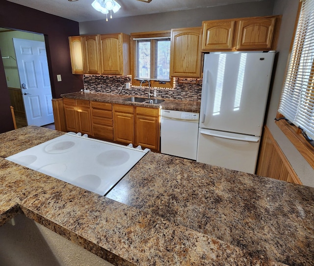 kitchen with white appliances, ceiling fan, decorative backsplash, and a sink