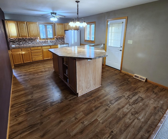 kitchen featuring white appliances, tasteful backsplash, visible vents, and dark wood-style flooring