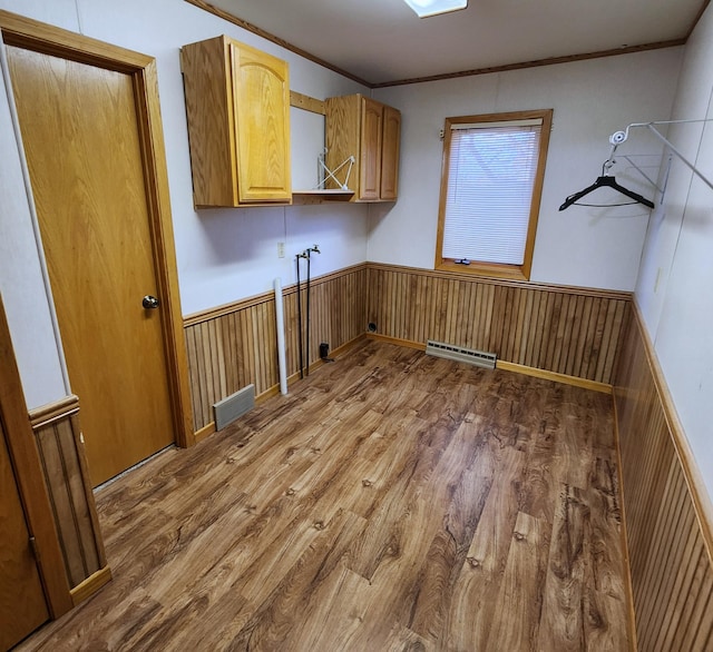 clothes washing area with a wainscoted wall, visible vents, washer hookup, wood finished floors, and cabinet space