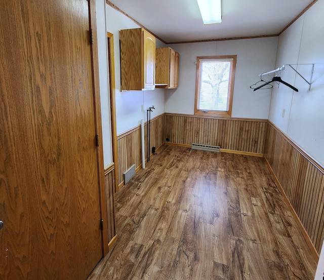 washroom featuring wainscoting, wood finished floors, visible vents, and cabinet space