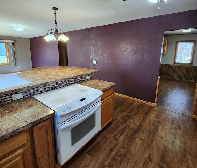 kitchen featuring white range with electric cooktop, brown cabinetry, hanging light fixtures, and dark wood-style flooring