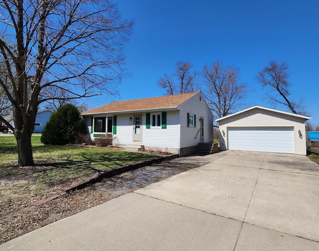 view of front of home featuring a shingled roof, a front lawn, entry steps, an outbuilding, and a detached garage