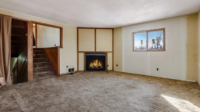 unfurnished living room with dark carpet and a textured ceiling