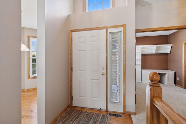 foyer with visible vents, baseboards, and wood finished floors