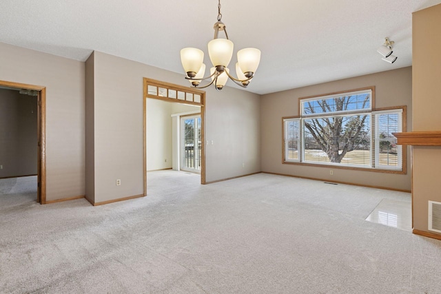 unfurnished room featuring baseboards, carpet, visible vents, and a chandelier