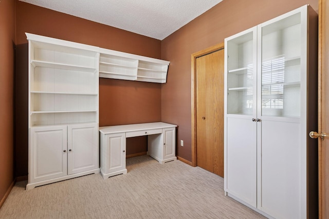 unfurnished office with light colored carpet and a textured ceiling