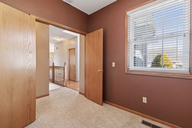 unfurnished room featuring visible vents, baseboards, and carpet