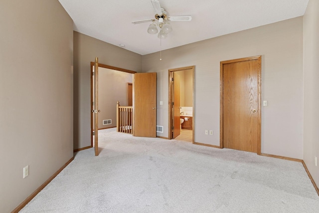 carpeted bedroom featuring visible vents, ensuite bath, baseboards, and a ceiling fan