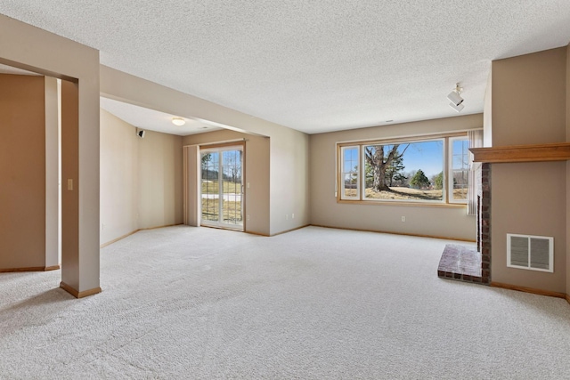 unfurnished living room featuring carpet flooring, baseboards, visible vents, and a textured ceiling