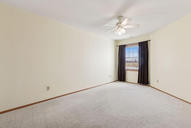 unfurnished room featuring baseboards, light carpet, a textured ceiling, and a ceiling fan