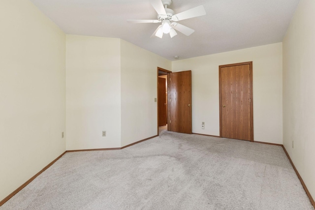 unfurnished bedroom featuring baseboards, light carpet, a closet, and a ceiling fan