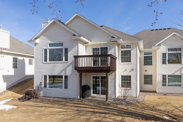 rear view of property with a shingled roof