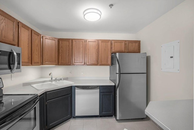 kitchen with appliances with stainless steel finishes, electric panel, sink, and light tile patterned floors