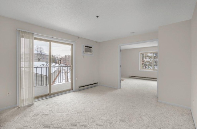 spare room featuring light colored carpet, a baseboard radiator, a wall mounted air conditioner, baseboard heating, and a healthy amount of sunlight