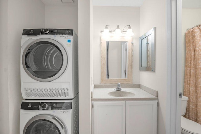 laundry room featuring stacked washer / drying machine, laundry area, and a sink