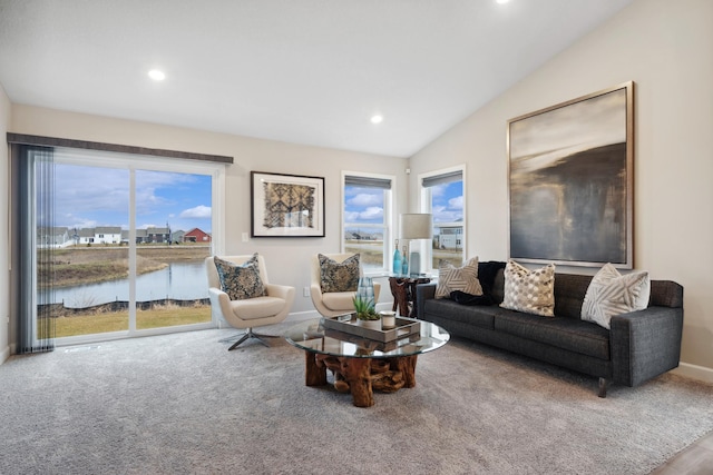 living room with a water view, lofted ceiling, and carpet