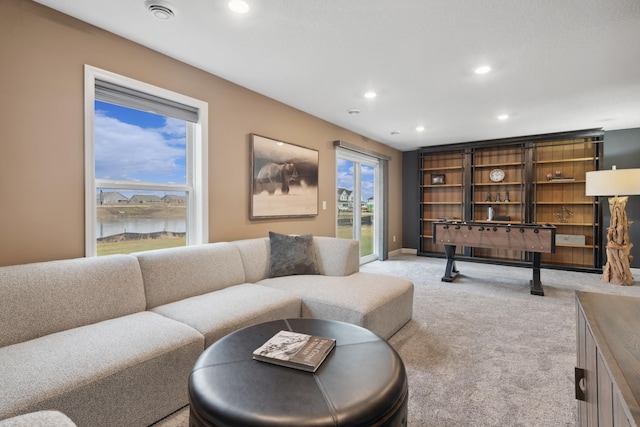 living room with light carpet and a water view