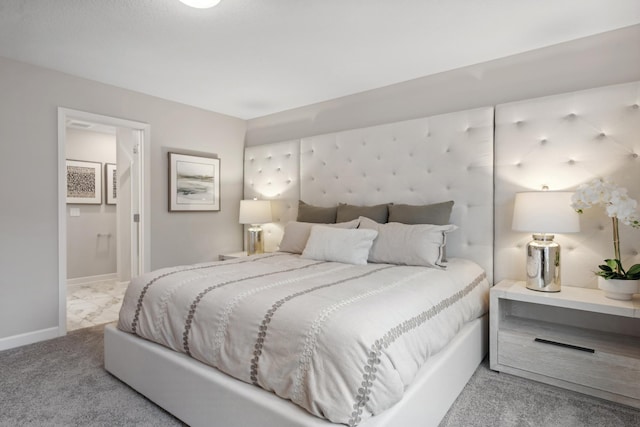 bedroom with ensuite bath and light carpet