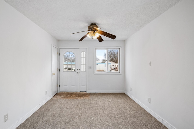 carpeted entryway featuring ceiling fan and a textured ceiling