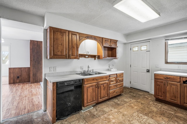 kitchen featuring sink, a textured ceiling, and black dishwasher