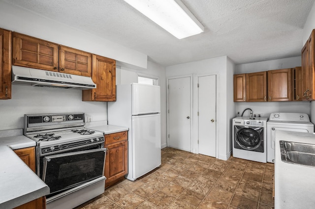 kitchen with separate washer and dryer, sink, white appliances, and a textured ceiling