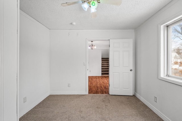 unfurnished bedroom with ceiling fan, carpet, and a textured ceiling