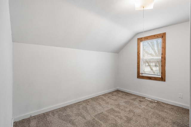 bonus room with lofted ceiling and carpet