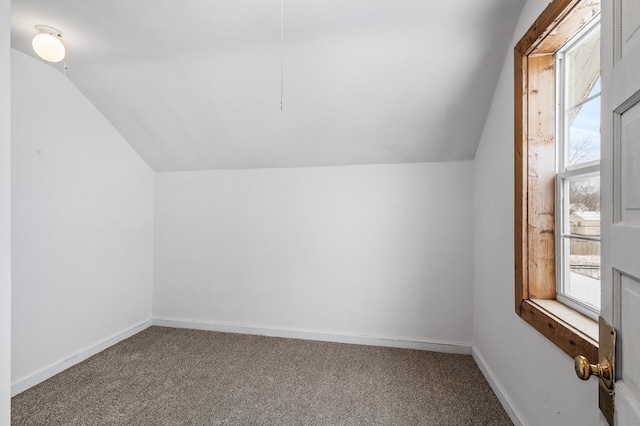 additional living space featuring lofted ceiling and carpet flooring