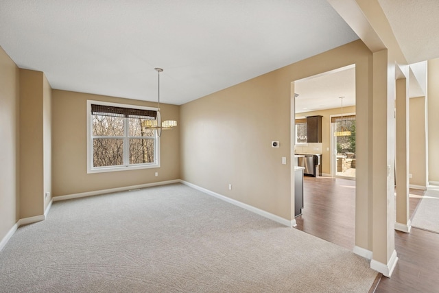 5270 Jewel Ln N, Plymouth, MN 55446 - unfurnished room with dark colored carpet, a chandelier, baseboards, and dark wood-style floors