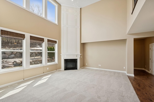 5270 Jewel Ln N, Plymouth, MN 55446 - unfurnished living room featuring a towering ceiling, plenty of natural light, baseboards, carpet, and a fireplace