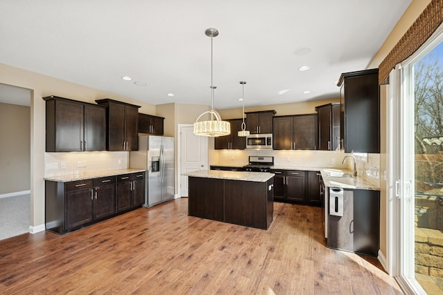 5270 Jewel Ln N, Plymouth, MN 55446 - kitchen with stainless steel appliances, a sink, a center island, dark brown cabinetry, and recessed lighting