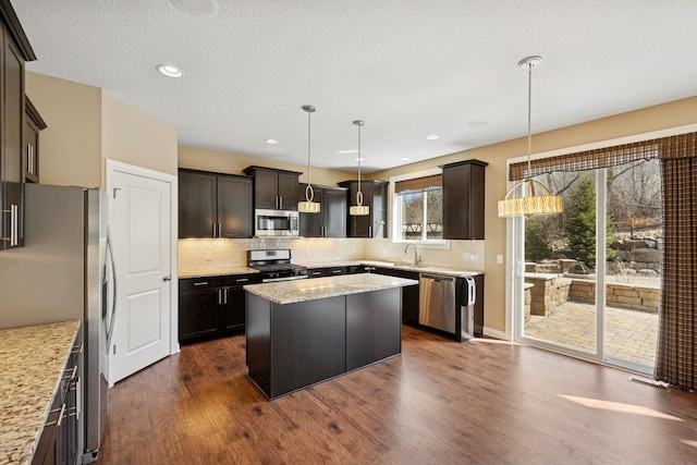 5270 Jewel Ln N, Plymouth, MN 55446 - kitchen featuring stainless steel appliances, a sink, dark wood-style flooring, a center island, and tasteful backsplash