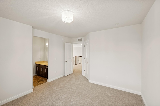 5270 Jewel Ln N, Plymouth, MN 55446 - unfurnished bedroom featuring light carpet, baseboards, ensuite bathroom, a textured ceiling, and a chandelier